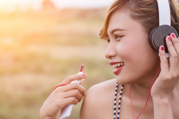 Крупным планом девушка слушает музыку с большой улыбкой