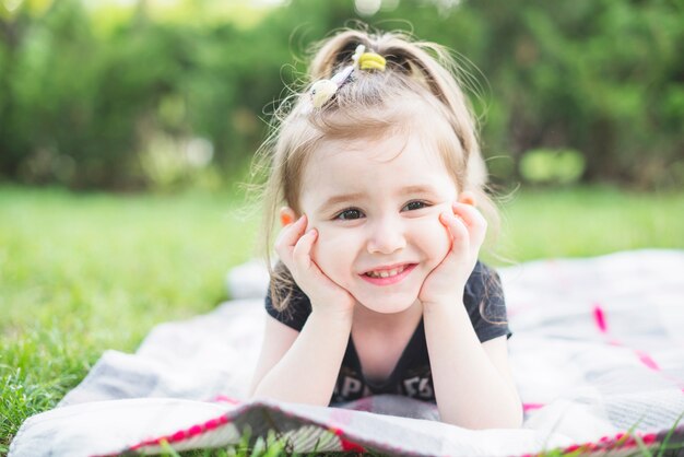 Close-up of a girl lying on blanket in the park