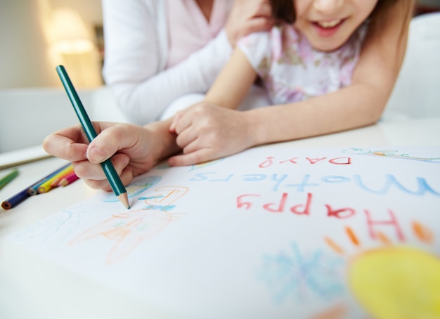 Close-up of girl painting with a crayon