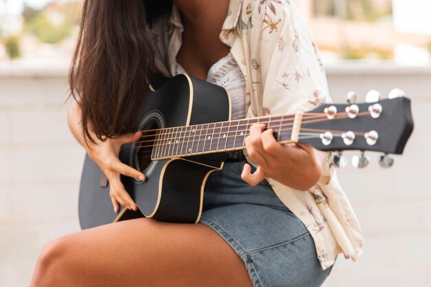 ギターを弾くクローズアップの女の子