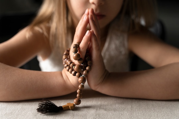 Крупным планом девушка молится с распятием