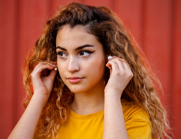 Close-up girl putting in earphones