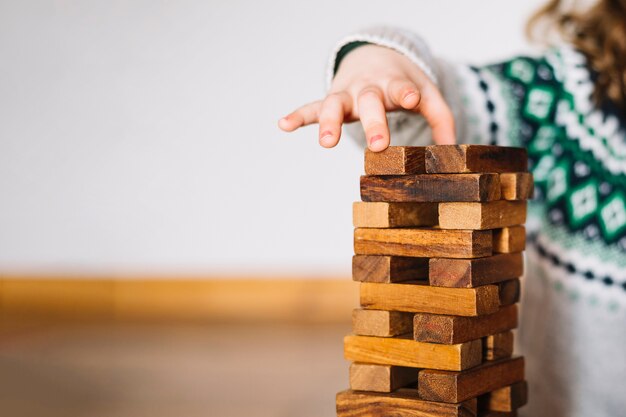 close-up of a girl's hand stacking wooden blocks
