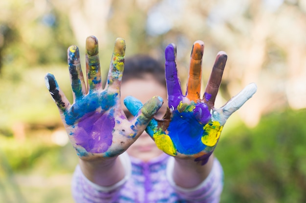 Close-up of a girl showing painted hands