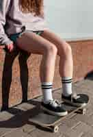 Free photo close up girl sitting on skateboard