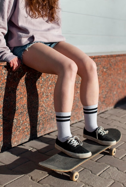 Close up girl sitting on skateboard