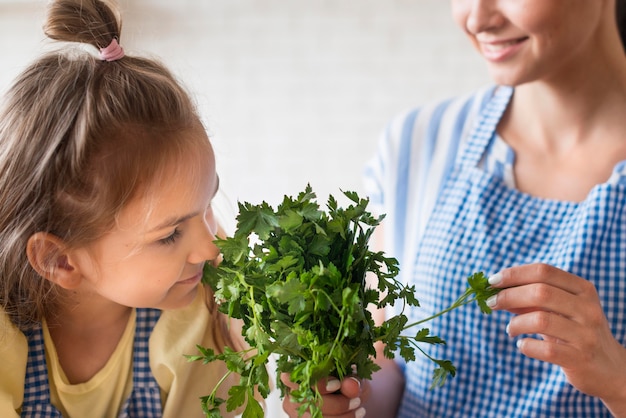 Free photo close-up girl smelling parsley