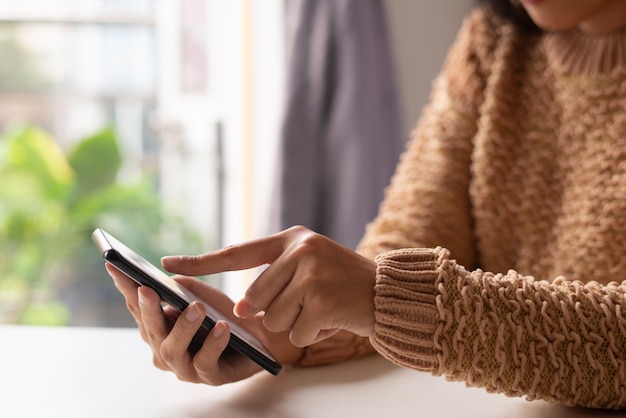 Foto gratuita primo piano della ragazza in maglione che osserva informazioni online