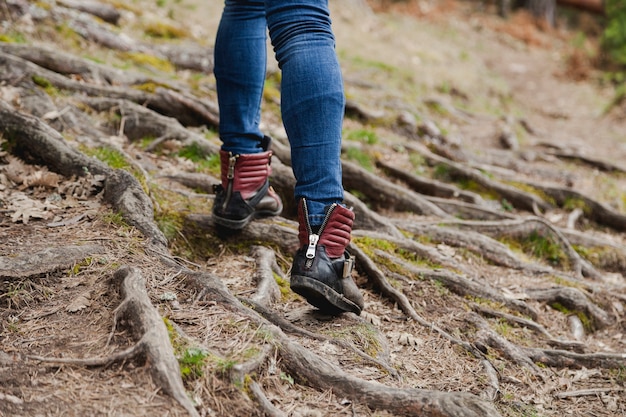 Close-up of girl walking on ground with roots
