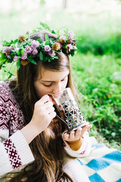 Close-up of a girl wearing wreath drinking glass of chocolate drinks
