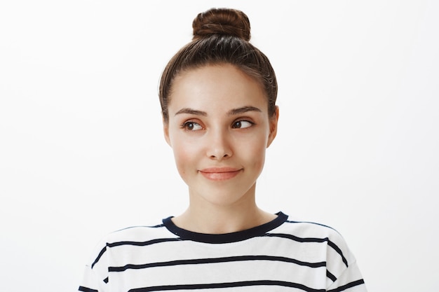 Foto gratuita primo piano della ragazza con la faccia sognante e premurosa, distogliendo lo sguardo con un tenero sorriso