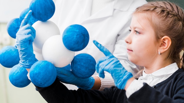 Close-up girl with gloves learning chemistry