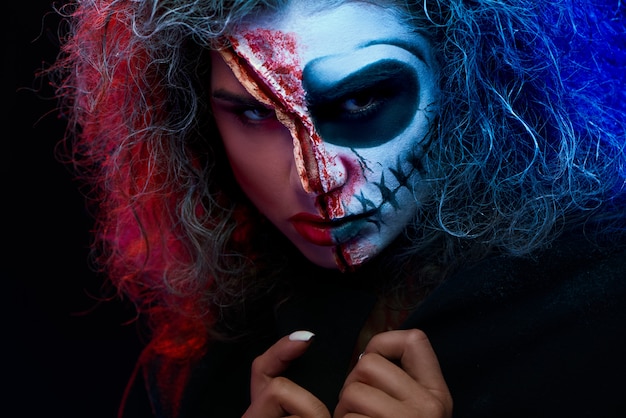 Close up of girl with halloween makeup wearing black cape