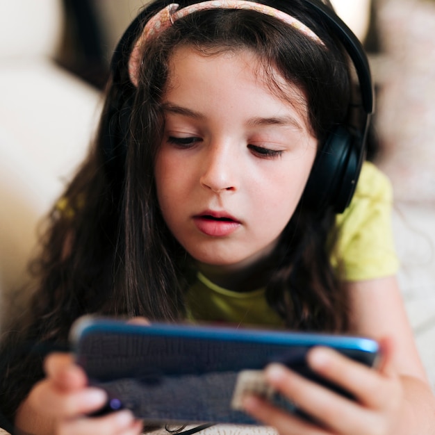 Close-up girl with headphones and smartphone