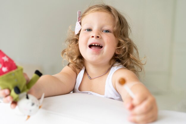 Close-up girl with lollipop and toy