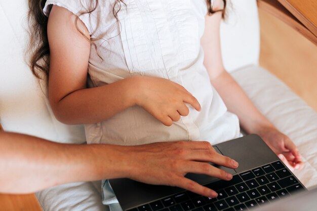 Close-up girl with parent looking at laptop