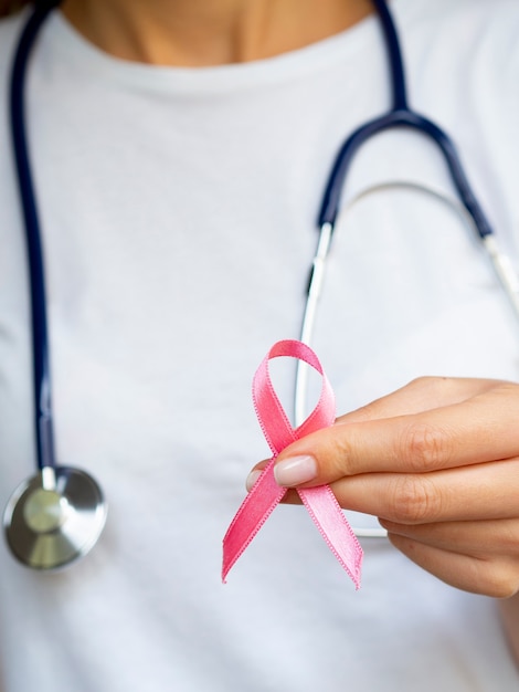 Close-up girl with pink ribbon and stethoscope