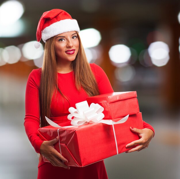Крупным планом девушка с Санта шляпу и подарки