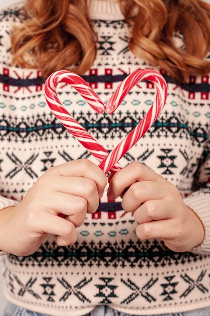 Free photo close-up girl with sweater holding candies