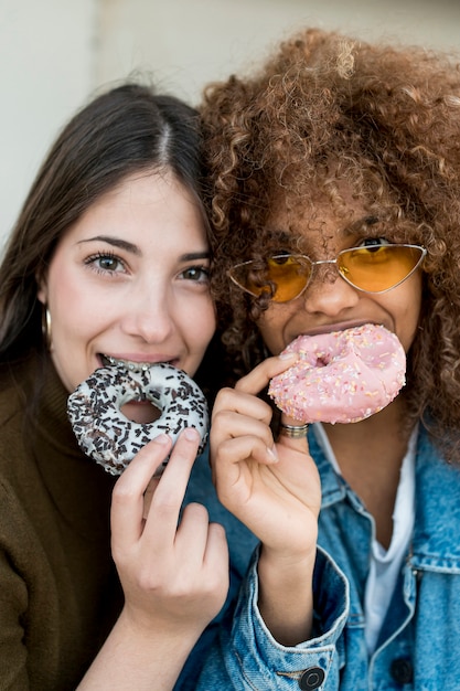 Close-up girls eating doughnuts