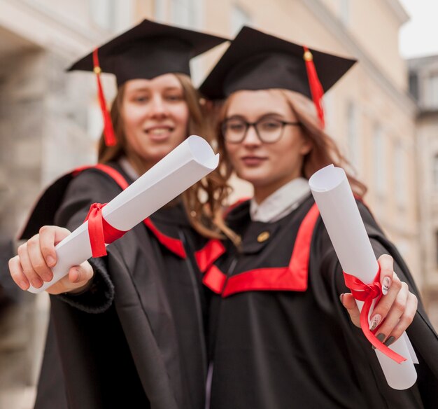 Close-up girls holding diploma