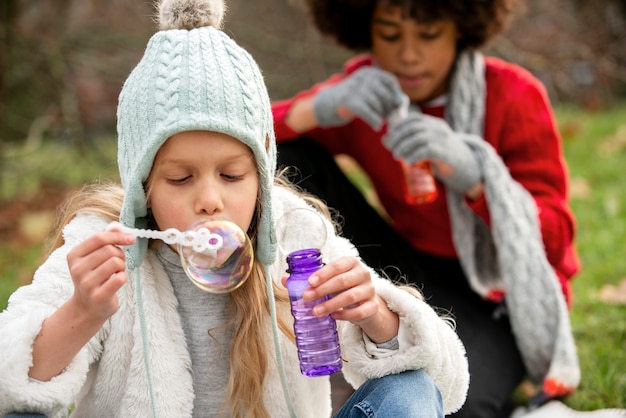 Close up girls making soap bubbles