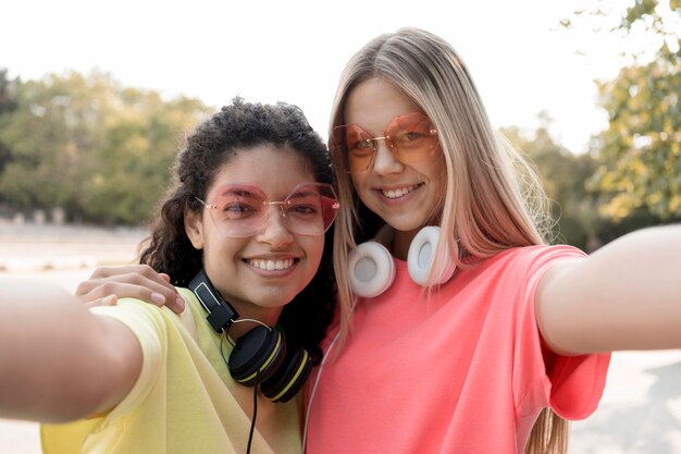 Foto gratuita ragazze del primo piano che prendono selfie insieme