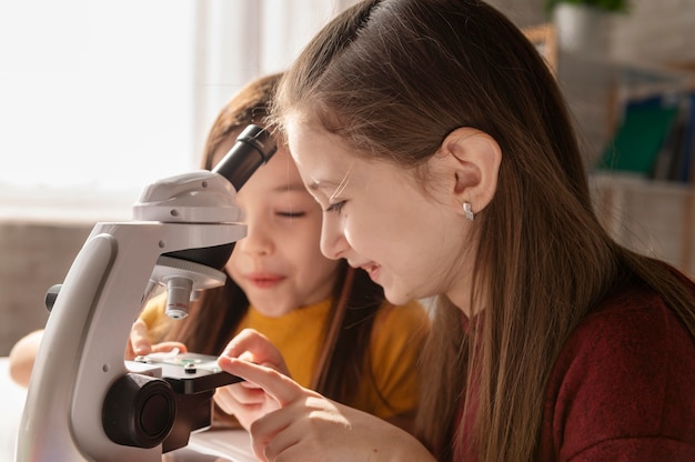 Free photo close up girls with microscope