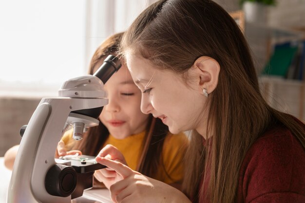 Close up girls with microscope