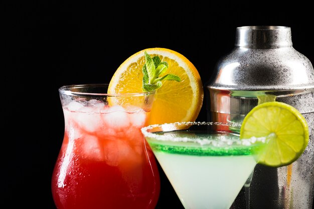 Close-up of glasses of cocktail with shaker and ice cubes