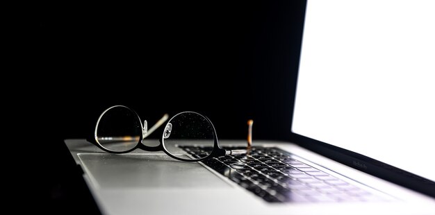 Close up of glasses on laptop in the dark