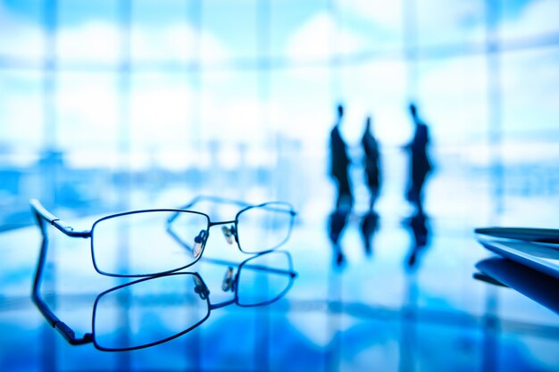 Close-up of glasses with employees background