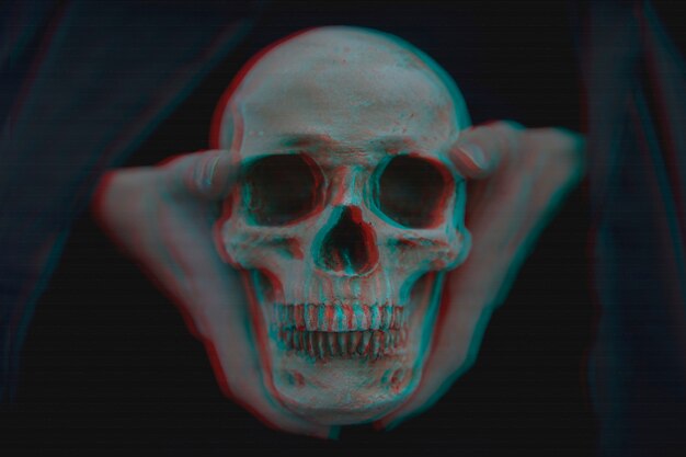 Close-up of glitched skull held in hands