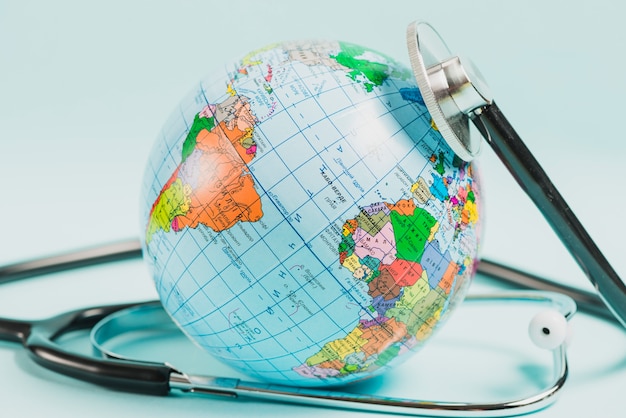 Close-up of globe with stethoscope against blue backdrop