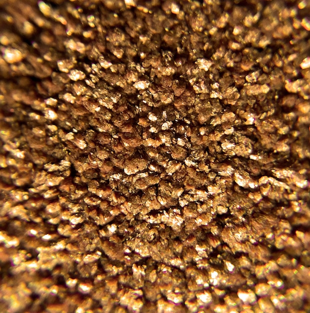 A close up of a gold piece of material with a circle of gold in the center.