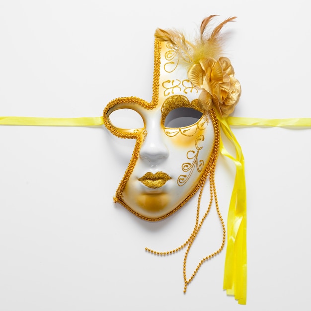 Close-up golden mask for carnival and yellow ribbons