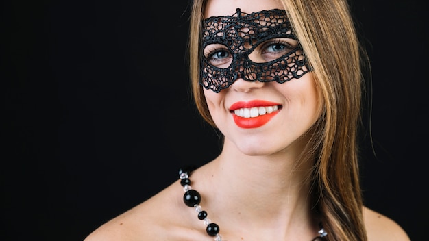 黒いカーニバルマスクでゴージャスな笑顔の女性のクローズアップ