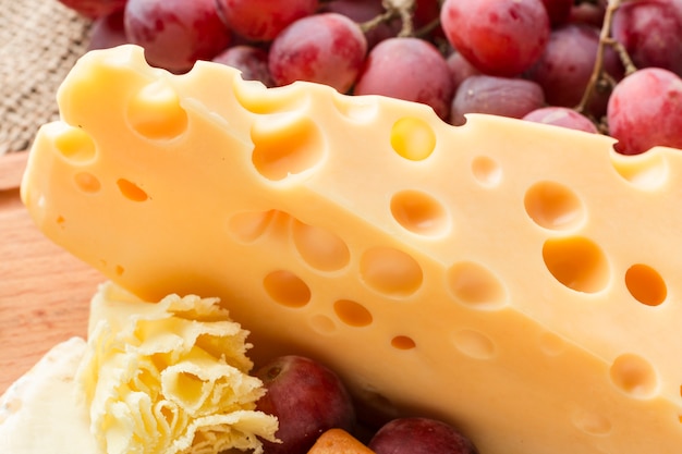 Close-up gourmet emmental cheese with grapes