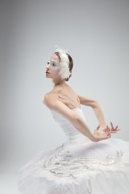 Close up of graceful classic ballerina dancing on white  background.
