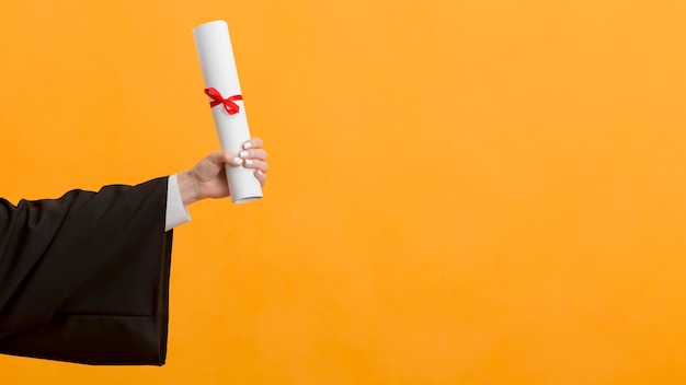 Close up graduate holding diploma