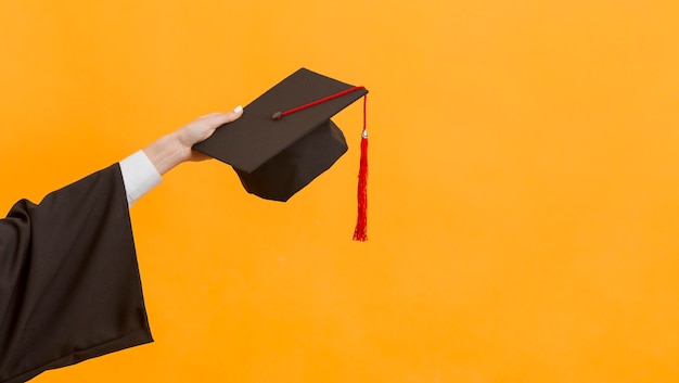 Close up graduate student holding cap