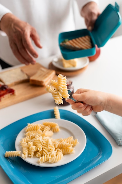 Close up grandkid holding fork with pasta