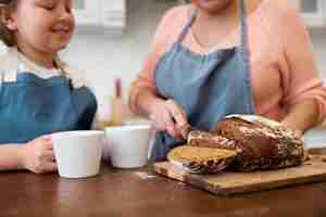 Free photo close up grandma cutting bread