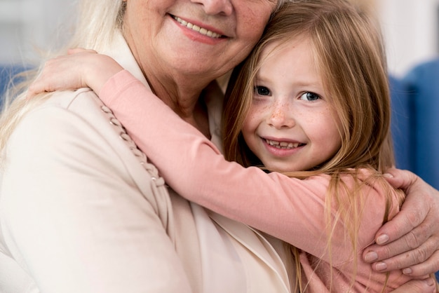 Close-up grandma and girl hugging