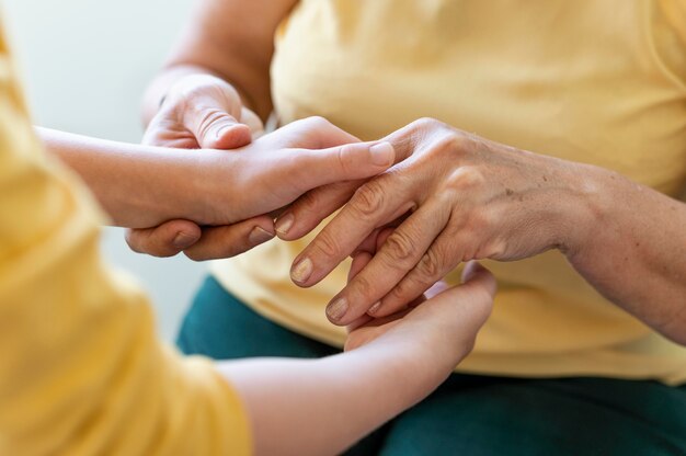 Close up grandmother holding kid hands
