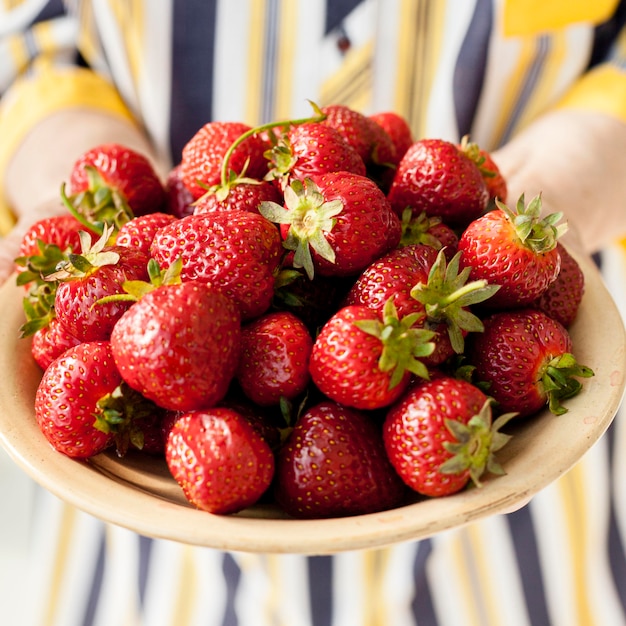 Close-up grandmother holding strawberries