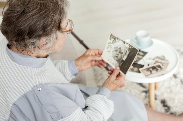 Foto gratuita nonna del primo piano che esamina le vecchie immagini