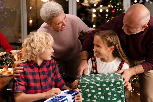 Close up on grandparents and kids opening gifts