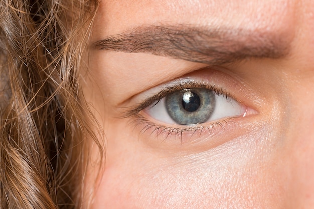 The close up gray eye on face of young beautiful caucasian girl