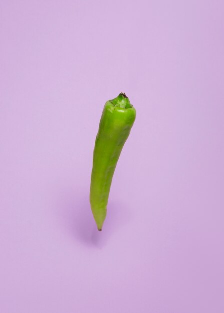 Close-up of a green chili pepper on purple background